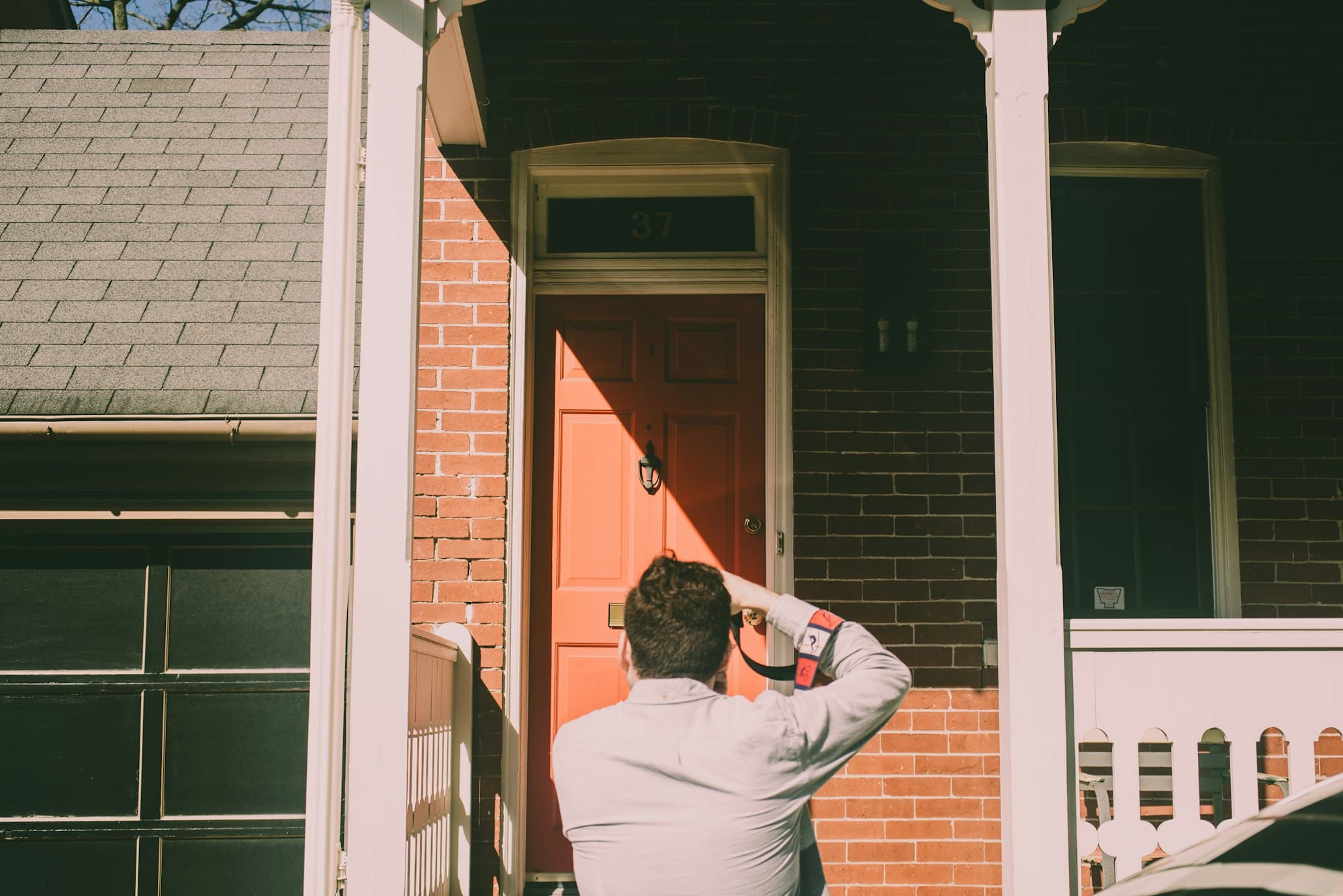 Person looking over the front of a brick house