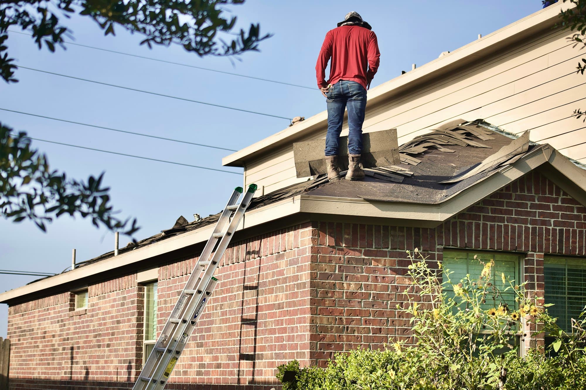 Roofer on the roof of a brick house